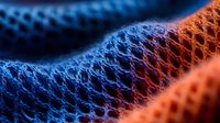 Macro view of colorful mesh fabric texture in blue and orange showing detailed net pattern structure with selective focus and soft lighting effects.