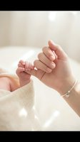 Tender moment of mother holding newborn baby tiny hand with delicate touch in soft natural light creating intimate bonding experience for family photography.