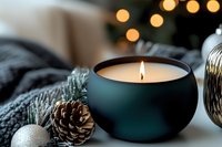 Cozy winter home decor with burning candle, pine cones, ornaments and warm bokeh lights creating peaceful holiday atmosphere for relaxation and comfort.