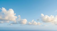 Bright blue sky with fluffy white clouds on sunny day. Natural cloudscape background for weather, nature, and outdoor concepts. Clear atmosphere scene.