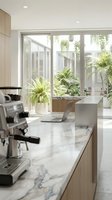 Modern kitchen interior with marble countertop, coffee machine and laptop overlooking tropical garden through large windows for contemporary home design.