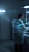 Futuristic holographic data visualization with glowing charts and graphs floating in modern office environment with blurred businessman in background.