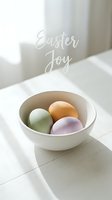 Pastel colored Easter eggs in a white ceramic bowl on a bright table with Easter Joy text, soft natural light spring holiday greeting card.