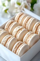 Fresh vanilla macarons with cream filling arranged in white gift box, selective focus on delicate French pastries showing smooth meringue texture.