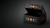 Elegant black gift box with copper moon phases design open on dark background for luxury packaging and celestial themed products.