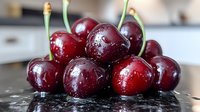 Fresh ripe dark red cherries with stems and water drops on black reflective surface, macro food photography for healthy eating and summer harvest.