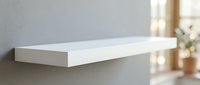 Modern white floating shelf mounted on gray wall in minimalist interior design for home decor and storage solutions.