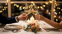 Romantic dinner date with couple toasting champagne glasses over candlelit table with roses and warm bokeh lights for anniversary celebration.