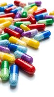 Colorful pharmaceutical capsules scattered on white background showing variety of medications and supplements for healthcare and medical treatment concepts.