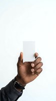 Male hand with dark skin tone holding blank white card against neutral background, isolated for business branding, marketing, and promotional design use.