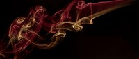 Abstract red and golden smoke swirls flowing gracefully against black background creating elegant wispy patterns for modern design projects.