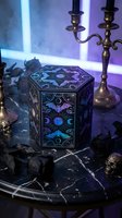 Mystical hexagonal jewelry box with celestial moon phases and ornate patterns on dark marble surface with brass candelabra and gothic skulls in moody lighting.