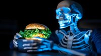 Glowing skeleton holding appetizing burger in dark setting with neon blue lighting, dramatic food photography concept highlighting unhealthy eating habits.