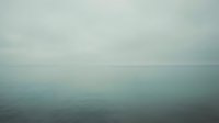 Calm ocean horizon with overcast sky and still water surface, suitable for backgrounds and peaceful nature concepts.