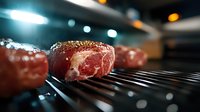 Raw marbled beef steak with seasoning on black grill grate, dramatic lighting with bokeh effect in dark moody restaurant kitchen atmosphere.