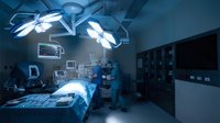 Modern operating room with surgical lights illuminated over patient bed, medical equipment and monitors visible in sterile hospital environment for healthcare procedures.