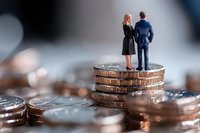 Business professionals standing on coin stack representing financial success and partnership growth in corporate investment concept.