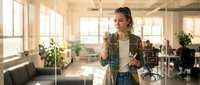Young professional woman interacting with futuristic holographic interface technology in modern office workspace for business innovation concepts.