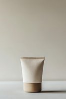Minimalist cosmetic cream tube in beige and white tones on neutral background, modern skincare packaging design for beauty and personal care products.