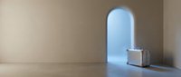 Minimalist interior with arched window, wooden floor, and stacked vintage suitcases casting shadows, evoking travel, wanderlust, and adventure themes for design and lifestyle projects.