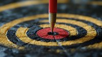 Red pencil pointing at center of dartboard target, extreme close-up view showing textured surface detail and concentric circles in yellow and black. Business concept.
