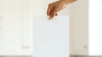 Close-up of male hand holding blank white paper sheet against neutral background, suitable for mockups, presentations, advertising campaigns, and design templates.