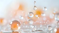 Transparent water drops with orange bokeh background creating magical macro photography effect. Pure crystal spheres reflect light in minimalist composition.