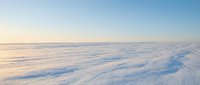 Aerial view of vast frozen landscape with snow-covered terrain and ice formations under clear sky, suitable for winter backgrounds and environmental concepts.