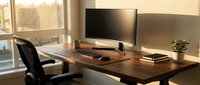 Modern home office workspace with wooden desk, dual monitor setup, ergonomic chair and natural lighting from large window for productivity and remote work.