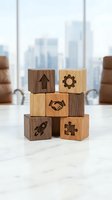 Wooden blocks with business icons stacked on office desk representing teamwork, growth, innovation and partnership in corporate environment.