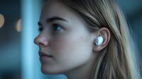 Young woman with blonde hair wearing wireless earbuds in profile view against blurred blue background with bokeh lights, expressing focused concentration.