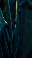 Luxurious teal velvet fabric with golden shimmer and soft folds, ideal for fashion, textile, and luxury design projects.