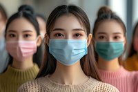 Young Asian women wearing protective face masks during pandemic outbreak, focus on central figure in medical blue mask and beige sweater. Healthcare concept.
