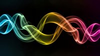 Abstract neon light waves flowing in rainbow colors creating dynamic energy patterns on dark background for modern digital designs.