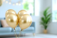 Golden metallic balloons floating in bright modern living room interior with blurred background and bokeh lights. Festive celebration atmosphere.