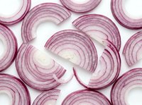 Fresh red onion slices showing natural concentric ring patterns on white background, perfect for culinary designs and cooking projects.
