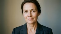 Professional mature Caucasian businesswoman in dark suit with confident expression and natural lighting for corporate headshot photography.