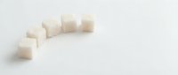 White sugar cubes arranged in a curved line on isolated background, suitable for food photography, culinary design, and beverage styling projects.