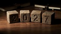 Wooden blocks spelling 2027 on a dark table, symbolizing new year planning, goals, and future business strategy concepts.