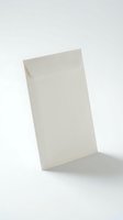 White paper envelope standing upright on light background, blank and sealed, suitable for mail, correspondence, and stationery design concepts.