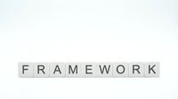 Word FRAMEWORK spelled with white letter tiles on a clean light background, conveying structure and strategy concepts.
