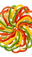 Sliced bell peppers in red, yellow, and green arranged in circular pattern on white background, isolated for culinary design and food preparation projects.
