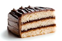 Layered vanilla cake slice with chocolate ganache coating and decorative striped pattern on top, photographed on white background for food marketing and menu design.