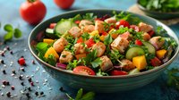 Fresh salmon poke bowl with mango, cucumber, cherry tomatoes, mixed greens and herbs in turquoise ceramic bowl on dark background. Healthy lunch concept.