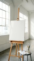 Wooden easel with blank canvas in bright art studio with large windows, paintbrushes and palette ready for creative painting session and artistic work.