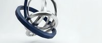 Abstract metallic rings in navy blue and silver creating dynamic geometric composition on white background for modern design projects.