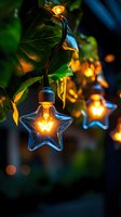 Glowing star-shaped string lights illuminate green foliage at dusk, creating magical garden atmosphere with warm golden bokeh and decorative outdoor lighting.