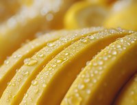Fresh ripe banana with water droplets on yellow peel, extreme close-up macro photography showing texture and moisture for food marketing.
