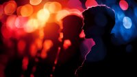 Romantic couple silhouettes kissing against vibrant bokeh lights background creating intimate atmosphere for love and relationship concepts.