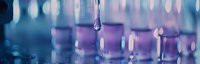 Macro shot of water drop falling with purple and blue bokeh background creating dreamy atmospheric effect. Suitable for wellness and spa marketing materials.